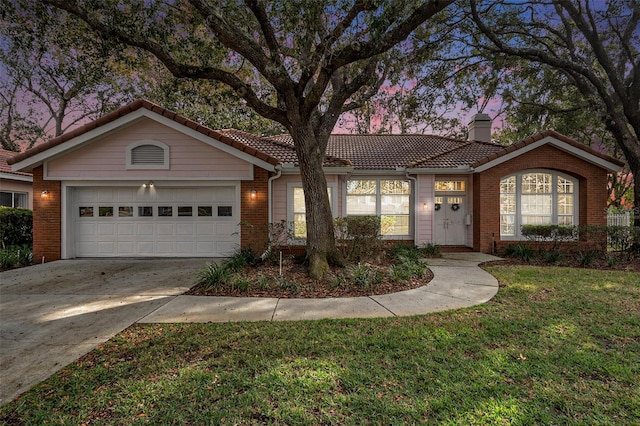 view of front of house with a garage and a lawn