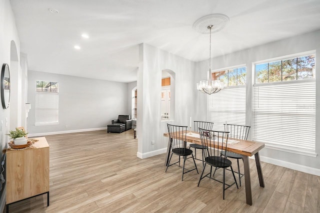 dining space with an inviting chandelier and light hardwood / wood-style flooring