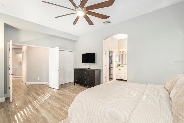 bedroom featuring ceiling fan, light hardwood / wood-style floors, and ensuite bath