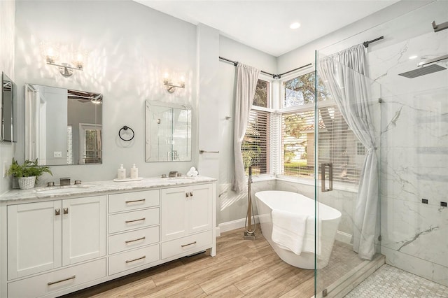 bathroom featuring shower with separate bathtub and vanity