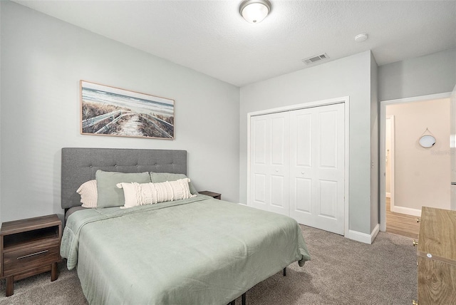 bedroom featuring carpet floors, a closet, and a textured ceiling