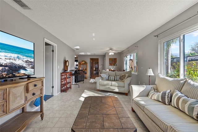 living room featuring ceiling fan and a textured ceiling