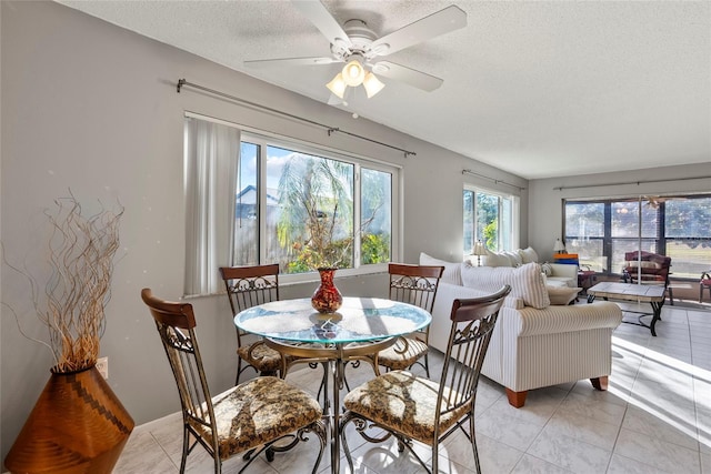 tiled dining space featuring ceiling fan and a textured ceiling