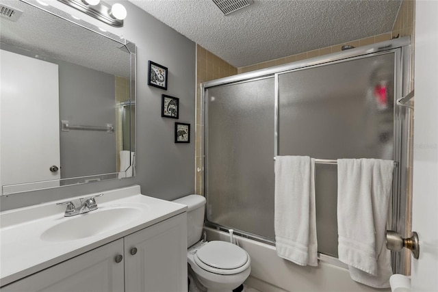 full bathroom with toilet, vanity, bath / shower combo with glass door, and a textured ceiling