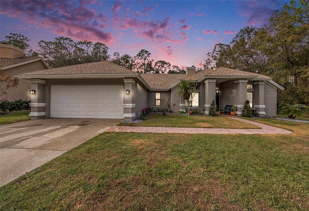 view of front of home featuring a garage and a yard