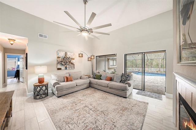 living room with ceiling fan and a fireplace