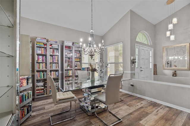 dining area with an inviting chandelier, high vaulted ceiling, and hardwood / wood-style floors