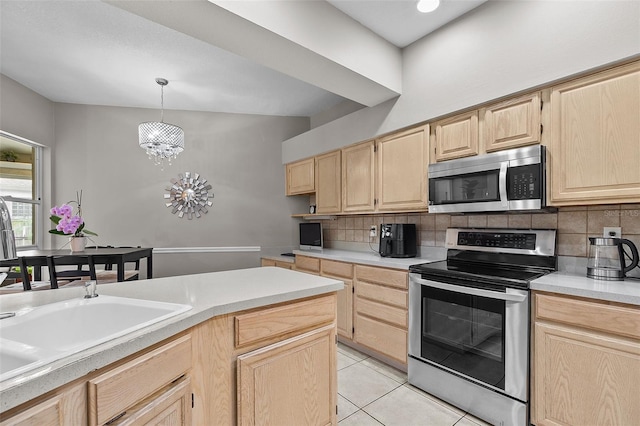 kitchen featuring light brown cabinetry, backsplash, hanging light fixtures, a chandelier, and appliances with stainless steel finishes