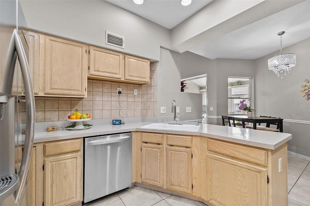 kitchen featuring sink, light brown cabinets, light tile patterned flooring, kitchen peninsula, and appliances with stainless steel finishes