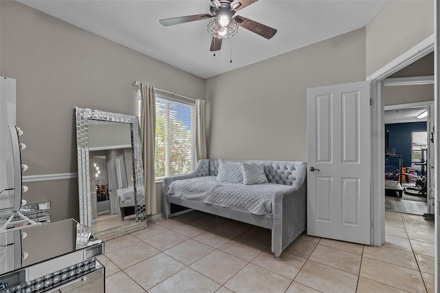 bedroom featuring light tile patterned flooring, a textured ceiling, and ceiling fan