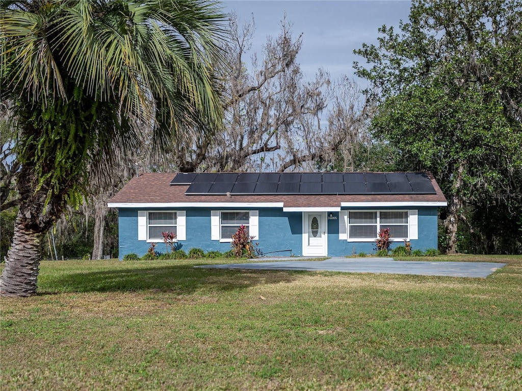 34027 Saint Joe Rd, Dade City, FL 33525 - ranch-style house featuring a front yard and solar panels