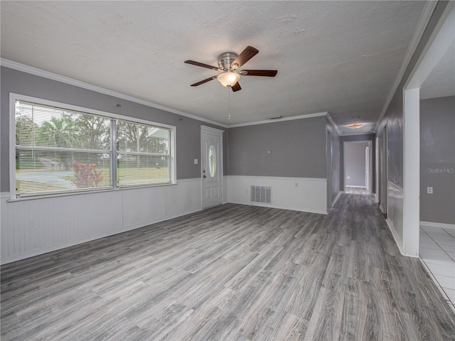 unfurnished living room with a wealth of natural light and ornamental molding