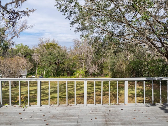 wooden deck featuring a lawn