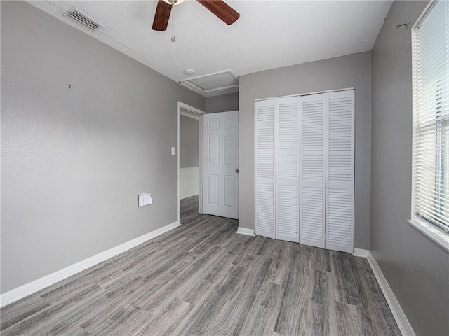 unfurnished bedroom with wood-type flooring, multiple windows, a closet, and ceiling fan