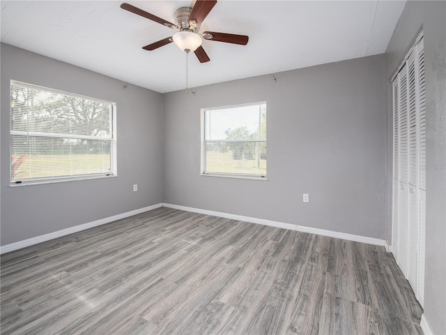 unfurnished bedroom with hardwood / wood-style floors, a closet, and ceiling fan