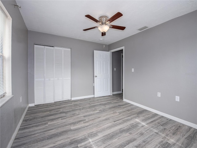 unfurnished bedroom with ceiling fan, light hardwood / wood-style floors, and a closet