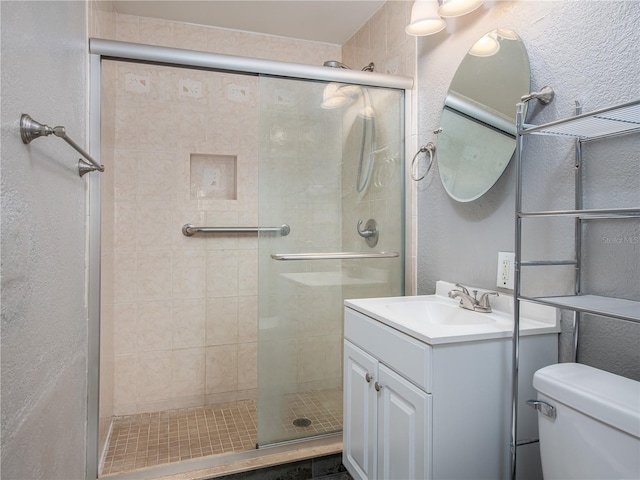 bathroom with toilet, an enclosed shower, and vanity