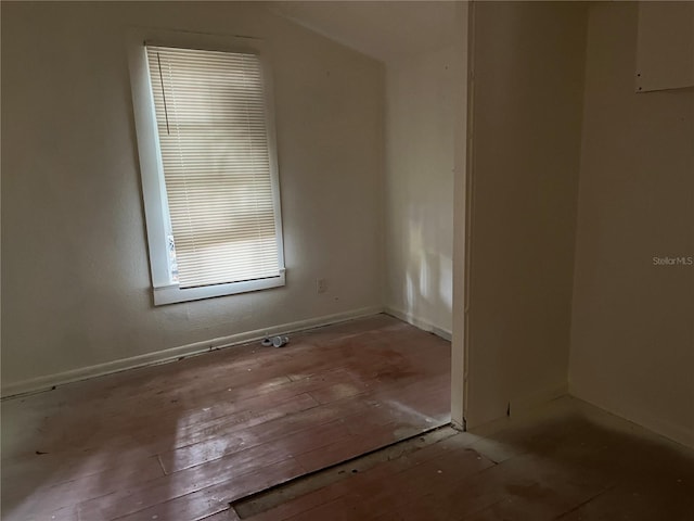 empty room with light hardwood / wood-style floors and vaulted ceiling