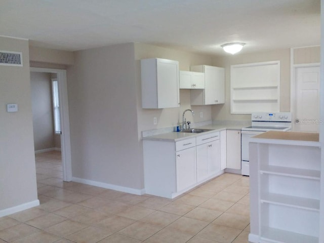 kitchen with white electric stove, sink, light tile patterned floors, and white cabinets