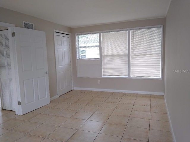 unfurnished bedroom with light tile patterned flooring