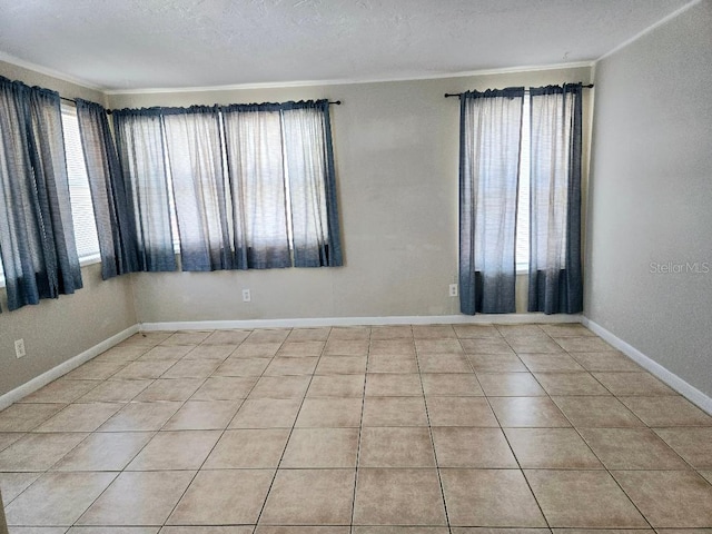 tiled spare room featuring crown molding and a textured ceiling