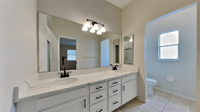 bathroom with tile patterned floors, vanity, toilet, and a shower with door