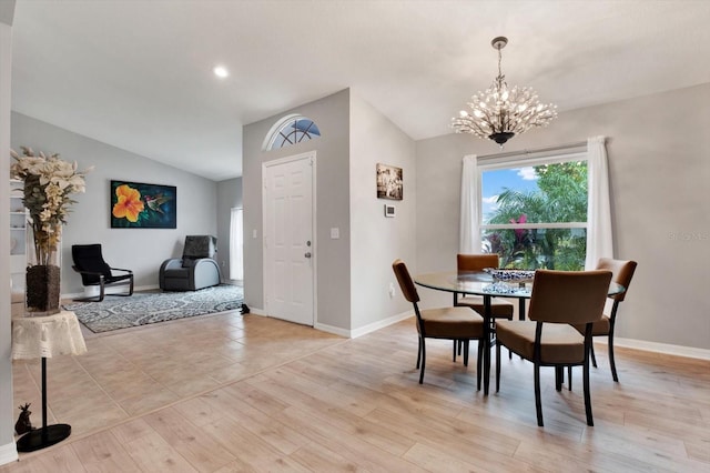 dining room with vaulted ceiling, an inviting chandelier, and light hardwood / wood-style floors