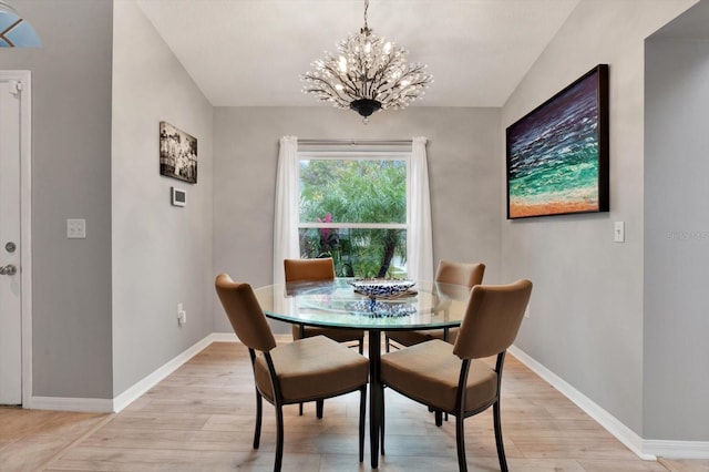 dining space featuring light hardwood / wood-style flooring and a notable chandelier