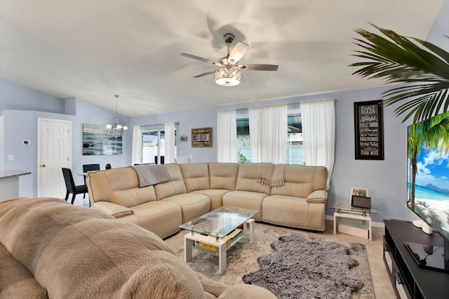 living room featuring ceiling fan with notable chandelier and lofted ceiling