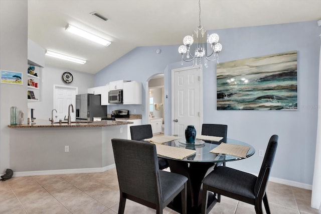 tiled dining area featuring vaulted ceiling, an inviting chandelier, and sink