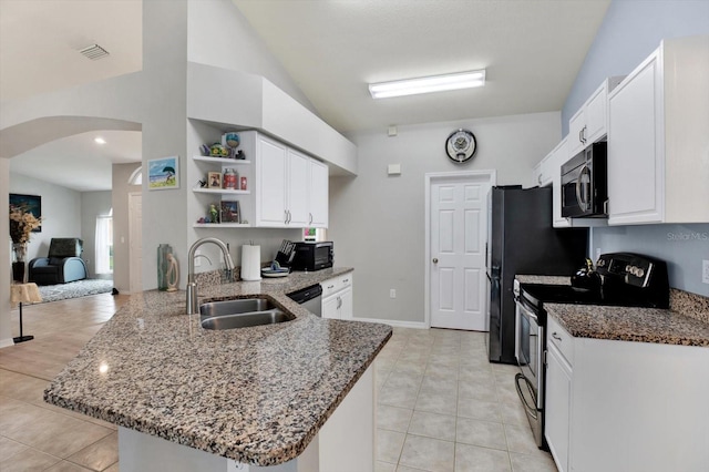 kitchen with appliances with stainless steel finishes, dark stone countertops, kitchen peninsula, and sink