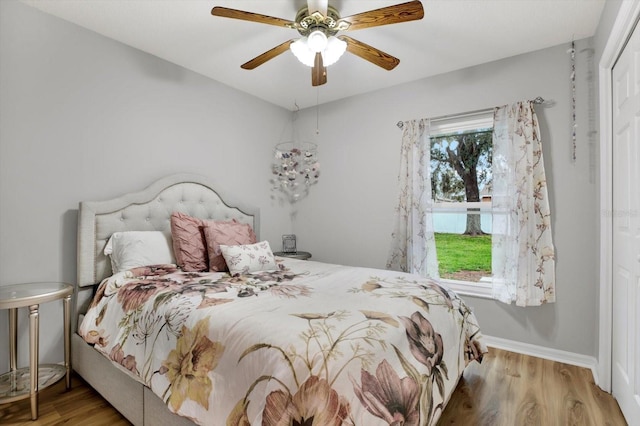 bedroom featuring ceiling fan, a closet, and hardwood / wood-style flooring