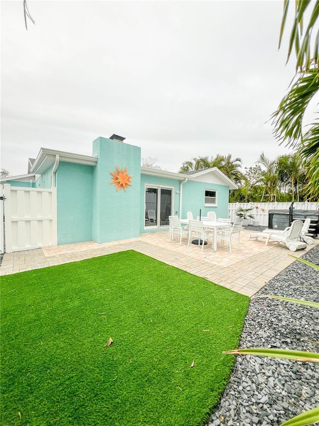 back of house featuring a lawn and a patio