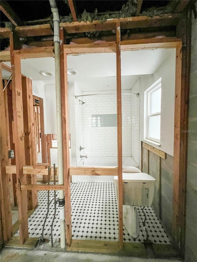 bathroom featuring concrete flooring and tiled shower / bath