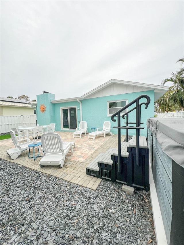 back of house featuring a hot tub