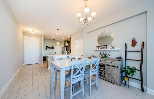 kitchen with stainless steel fridge, hanging light fixtures, and a notable chandelier