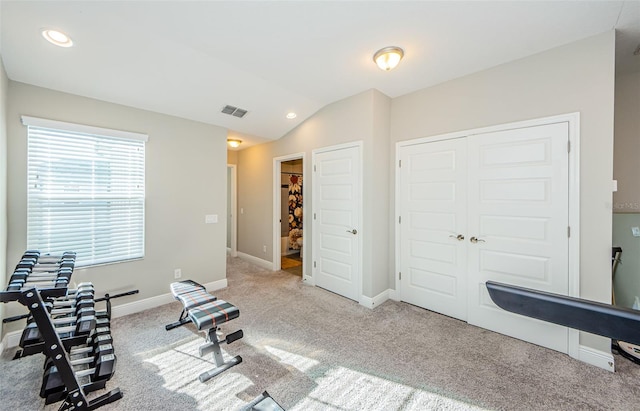 exercise area with light colored carpet and lofted ceiling