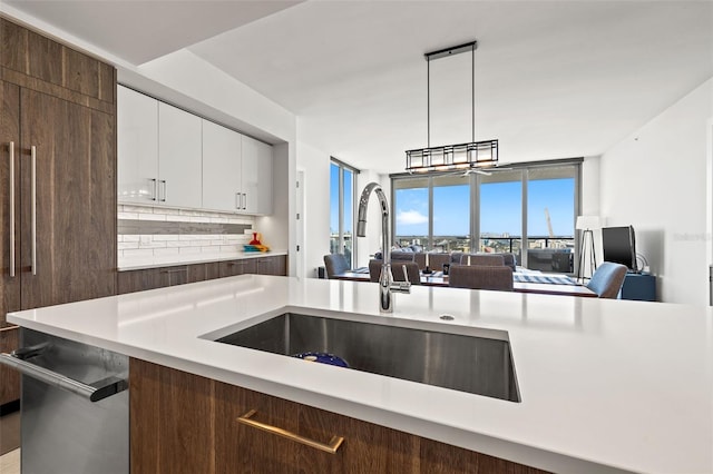 kitchen with decorative light fixtures, decorative backsplash, sink, white cabinetry, and dark brown cabinetry