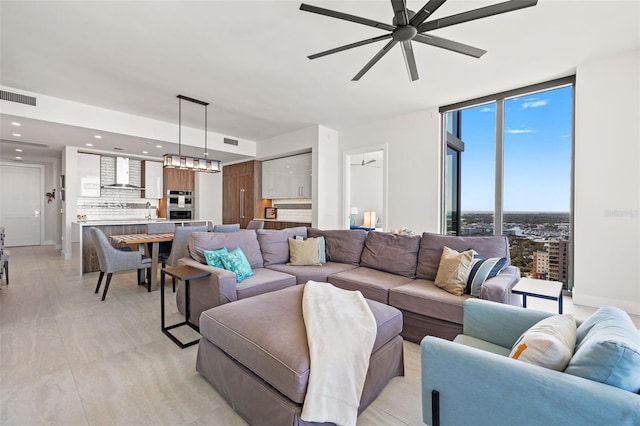 living room featuring ceiling fan, floor to ceiling windows, and sink