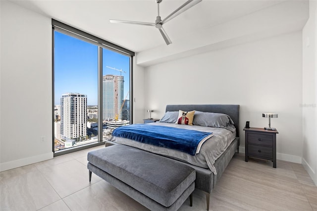 tiled bedroom featuring ceiling fan and floor to ceiling windows