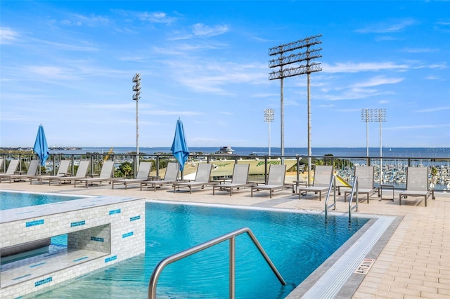 view of pool featuring a patio area and a water view