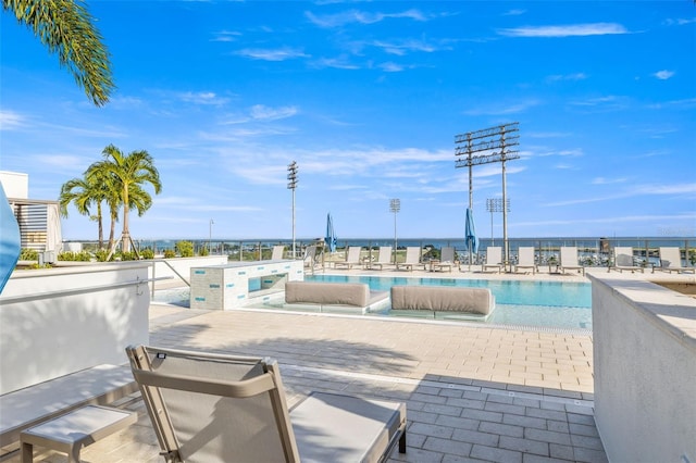 view of swimming pool featuring a patio area and a water view