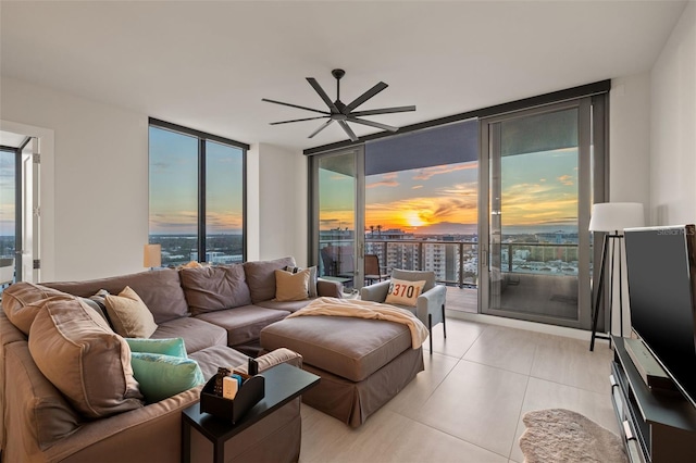 living room with ceiling fan, light tile patterned flooring, and a wall of windows