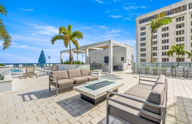 view of patio featuring an outdoor living space with a fire pit, a water view, and an outdoor bar