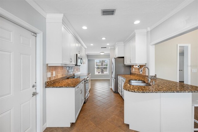 kitchen featuring sink, white cabinetry, kitchen peninsula, and appliances with stainless steel finishes