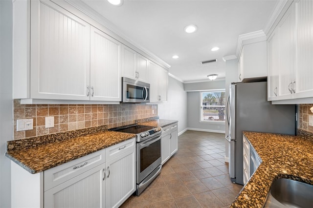 kitchen featuring stainless steel appliances, white cabinets, and ornamental molding