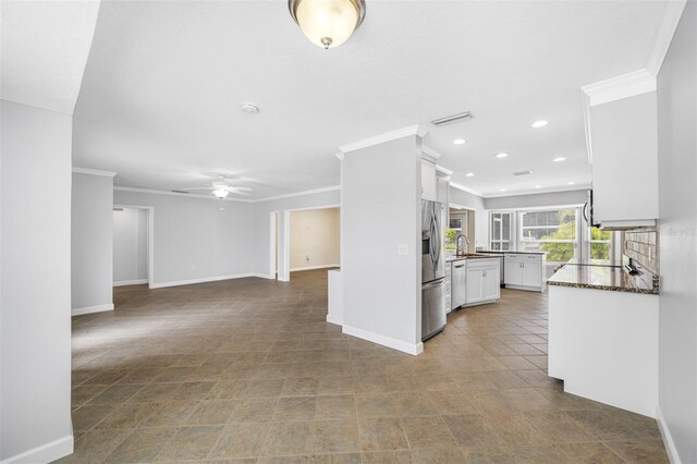 interior space featuring ceiling fan, crown molding, and sink