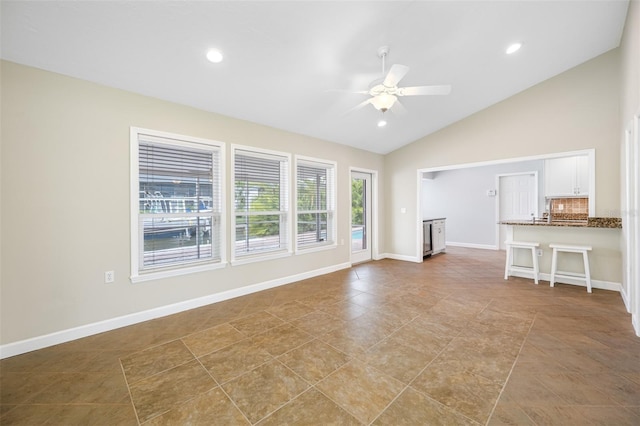 unfurnished living room with ceiling fan, light tile patterned flooring, and lofted ceiling