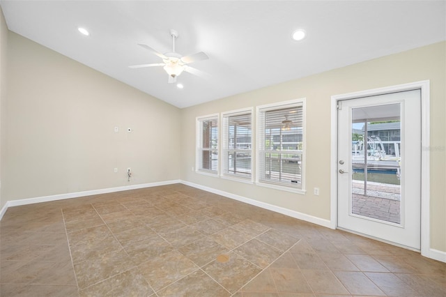 empty room featuring vaulted ceiling, ceiling fan, and light tile patterned floors