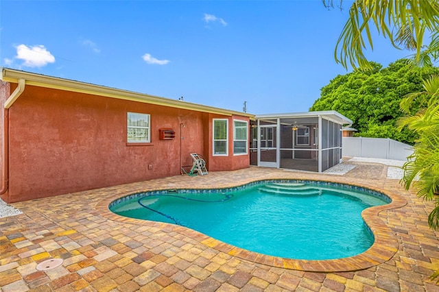 view of swimming pool with a sunroom and a patio